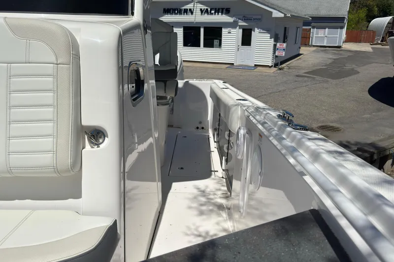 Slide: The Image of 2026 Edgewater 262CC boat interior with white seating, docked near Modern Yachts office. - 41