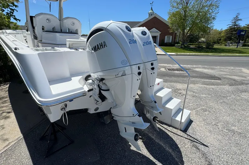 Slide: The Image of 2026 Edgewater 262CC boat with twin Yamaha 200 engines, parked with access stairs. - 6