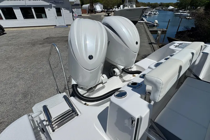 Slide: The Image of 2026 Edgewater 262CC boat with dual outboard engines docked at a marina. - 8