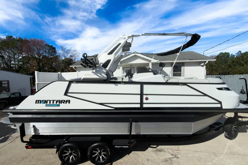 Slide: The Image of 2026 Montara Surf Boss 2.0 SL 23" boat on trailer, parked outdoors. - 1