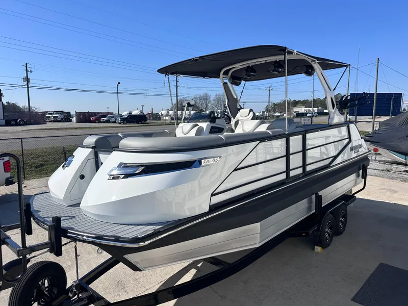 Slide: The Image of 2025 Montara Surf Boss 2.0 - SL 25' boat on trailer, sleek design, outdoor setting. - 2