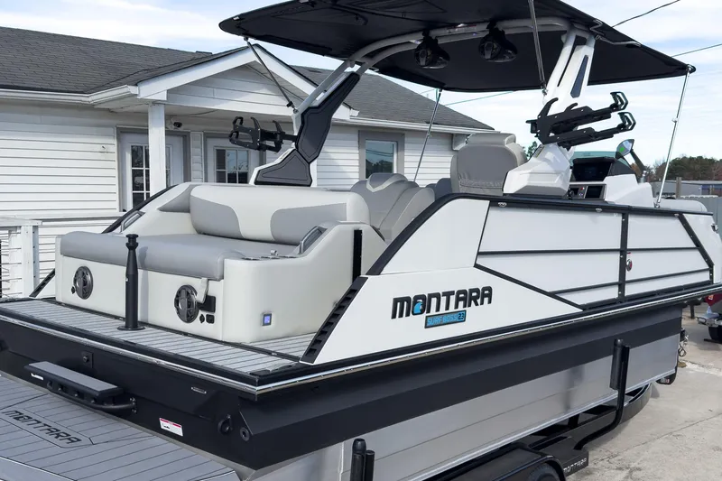 Slide: The Image of 2026 Montara Surf Boss 2.0 SL 23" boat, sleek design, docked near a house. - 4