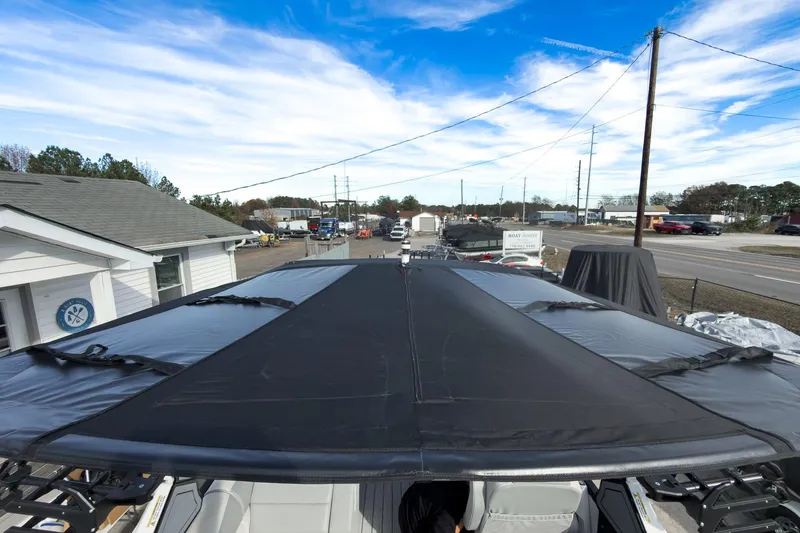 Slide: The Image of 2026 Montara Surf Boss 2.0 SL 23" boat with black canopy, parked near a road. - 43