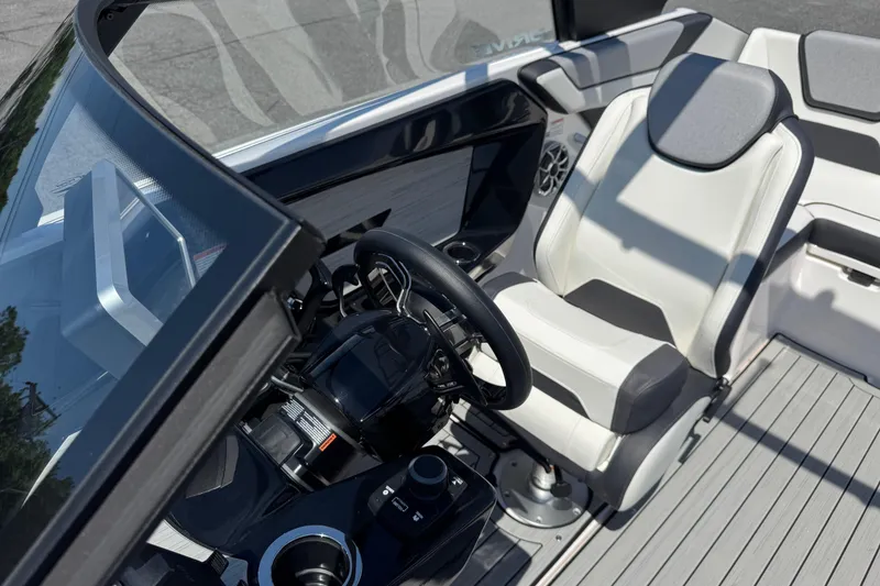 Slide: The Image of 2023 Yamaha Boats 222SD cockpit with steering wheel and white seating. - 10