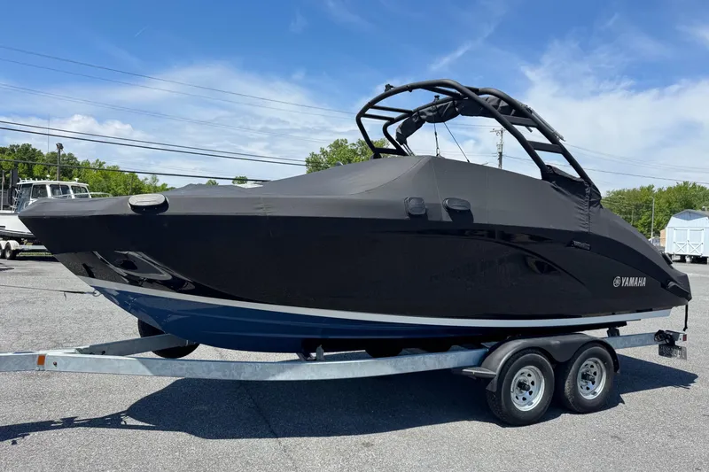 Slide: The Image of 2023 Yamaha Boats 222SD covered on trailer, parked outdoors under blue sky. - 3