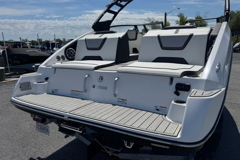 Slide: The Image of 2023 Yamaha Boats 222SD, sleek design, spacious seating, docked under clear skies. - 9
