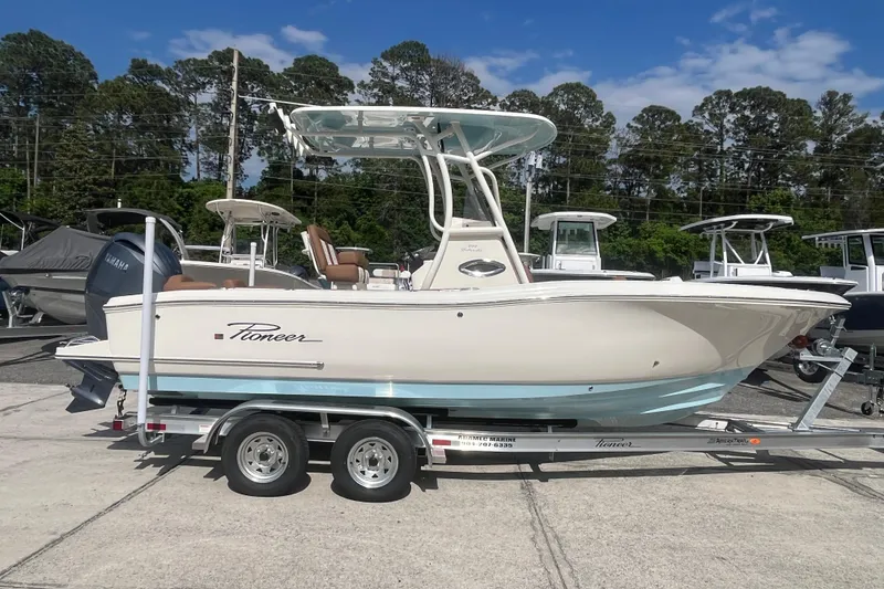 Slide: The Image of 2026 Pioneer 222 Islander boat on trailer, parked outdoors under blue sky. - 10