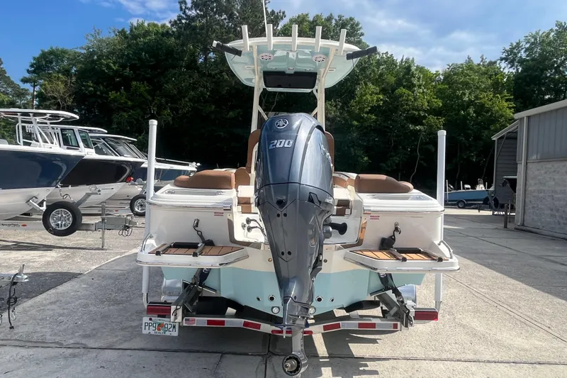 Slide: The Image of 2026 Pioneer 222 Islander boat with powerful outboard motor, parked outdoors. - 13