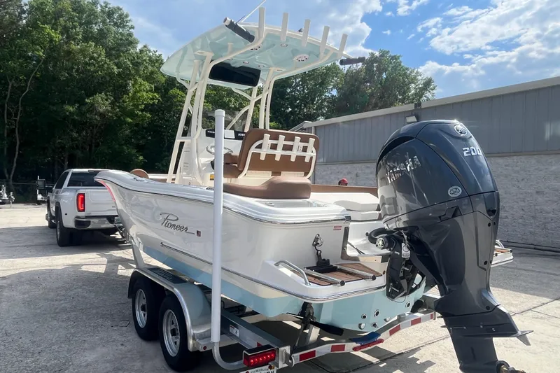 Slide: The Image of 2026 Pioneer 222 Islander boat on trailer, featuring Yamaha 200 engine, parked outdoors. - 14