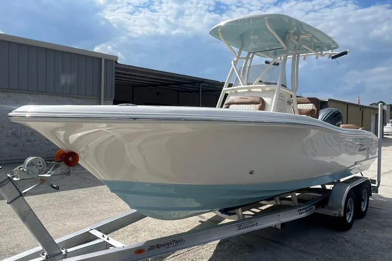 Slide: The Image of 2026 Pioneer 222 Islander boat on trailer, parked outdoors under a partly cloudy sky. - 16
