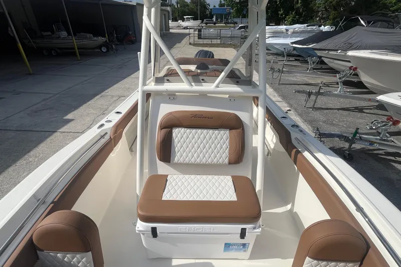 Slide: The Image of 2026 Pioneer 222 Islander boat interior with brown and white seating, docked at a marina. - 22