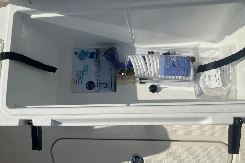 Slide: The Image of Open storage compartment on 2026 Pioneer 222 Islander boat with Engel product guide and accessories. - 27