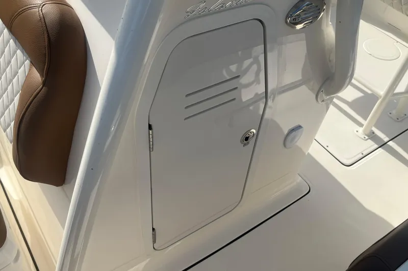 Slide: The Image of 2026 Pioneer 222 Islander boat interior with brown cushioned seating and storage compartment. - 29