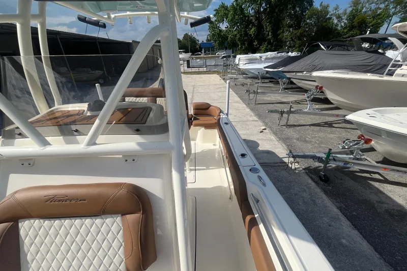 Slide: The Image of 2026 Pioneer 222 Islander boat with tan seating, docked among other boats. - 31