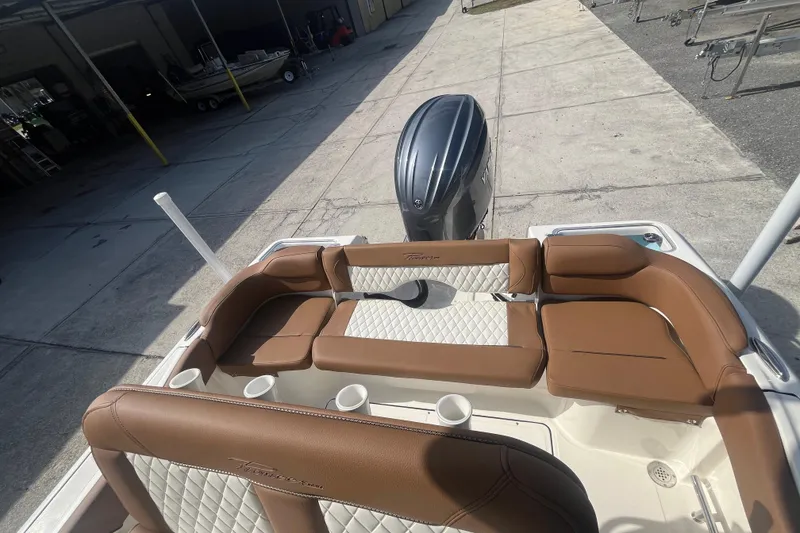 Slide: The Image of 2026 Pioneer 222 Islander boat interior with brown leather seating and outboard motor. - 40