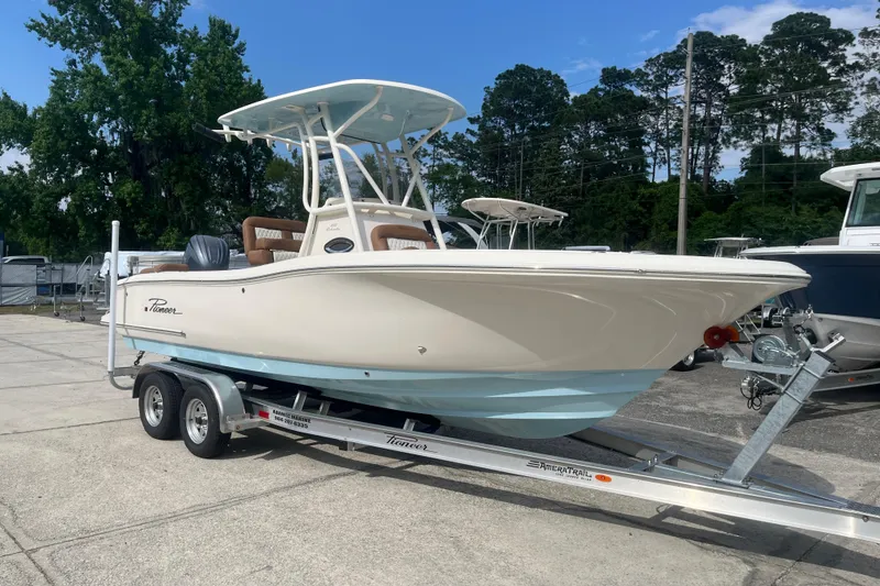 Slide: The Image of 2026 Pioneer 222 Islander boat on trailer, parked outdoors with trees in background. - 9