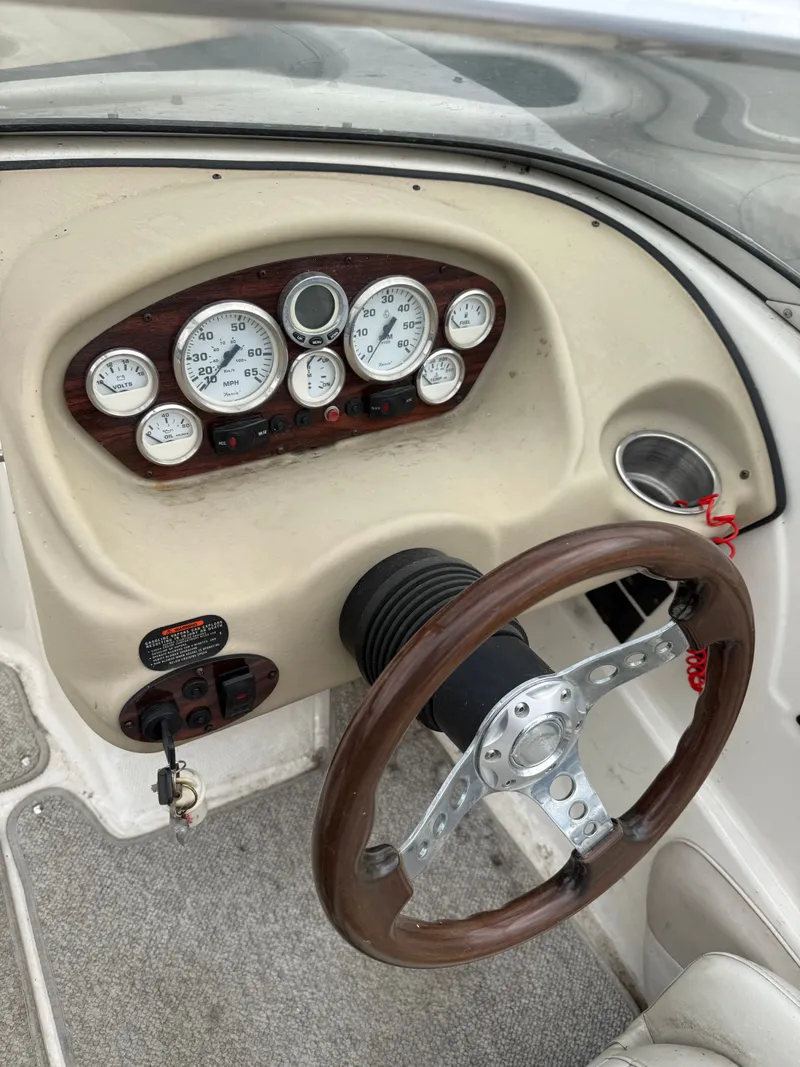 Slide: The Image of Dashboard of a 2008 Glastron GT 225 boat with wooden steering wheel. - 2