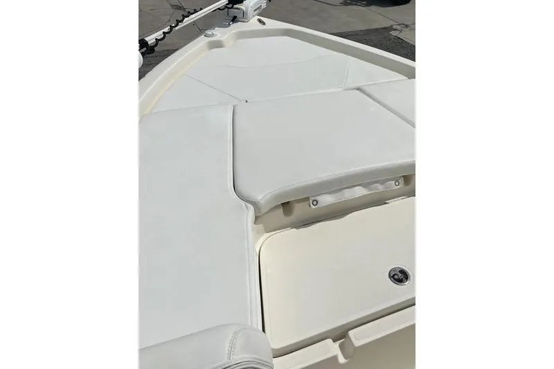 Slide: The Image of 2021 Skeeter SX2250 boat deck with white cushioned seating and storage compartment. - 12