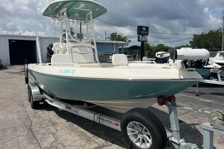 Slide: The Image of 2021 Skeeter SX2250 boat on trailer, parked outdoors under cloudy sky. - 2