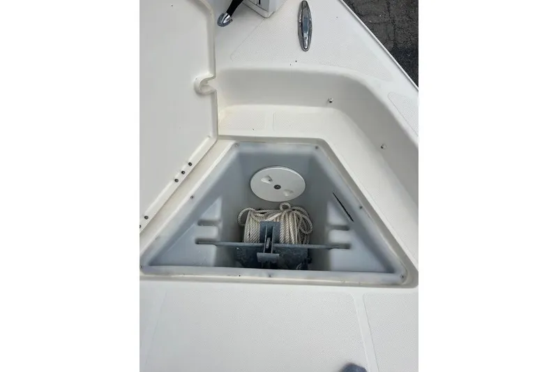 Slide: The Image of Anchor storage compartment on a 2021 Skeeter SX2250 boat, featuring coiled rope and anchor. - 20