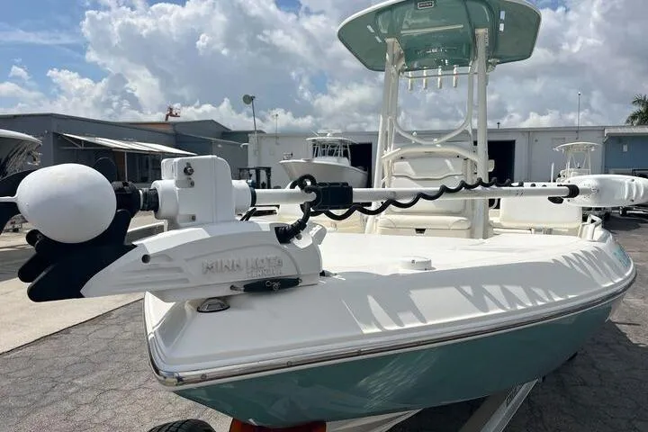 Slide: The Image of 2021 Skeeter SX2250 boat with trolling motor, parked outdoors under a cloudy sky. - 7