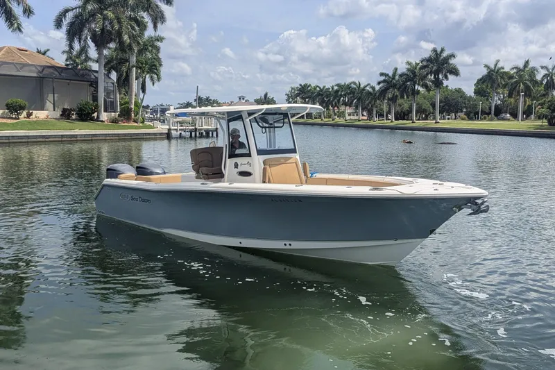 The Image of 2021 Sea Hunt Gamefish 30 boat on a calm waterway with palm trees. - 1