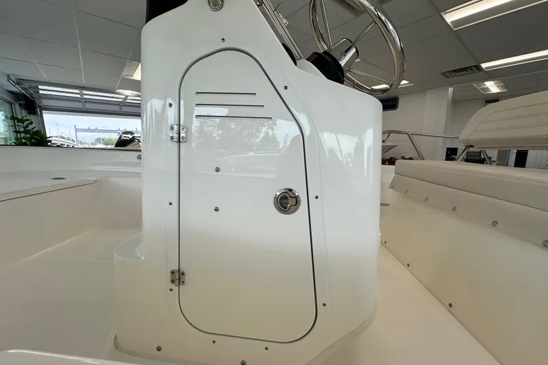 Slide: The Image of 2026 Boston Whaler 150 Montauk boat interior, featuring sleek white console and seating. - 29