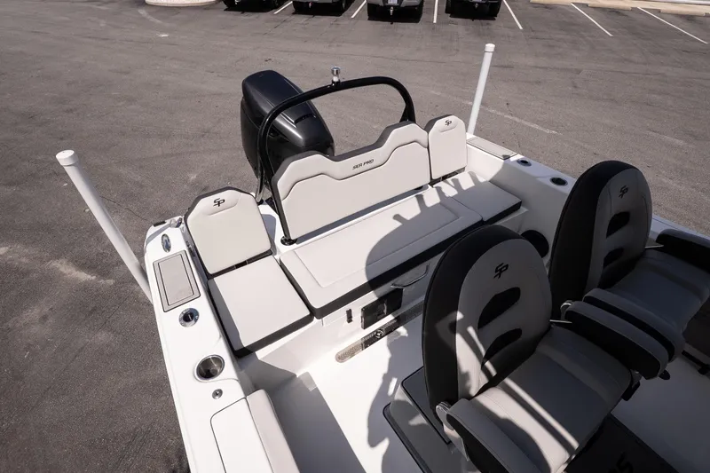 Slide: The Image of 2026 Sea Pro 245FLXR Sandbar boat interior with seating and motor, parked on asphalt. - 11
