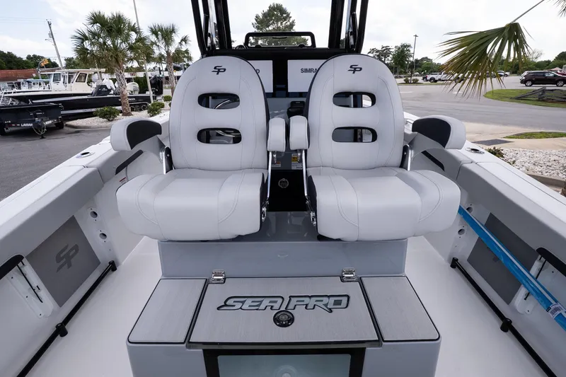 Slide: The Image of 2026 Sea Pro 245FLXR Sandbar boat interior with dual white seats and palm trees in background. - 14