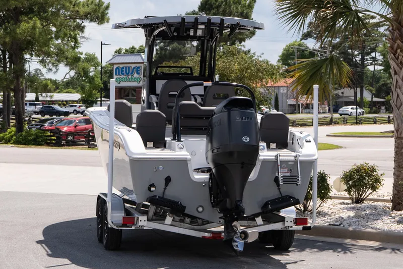 Slide: The Image of 2026 Sea Pro 245FLXR Sandbar boat on trailer, parked outdoors near palm trees. - 4