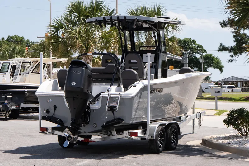 Slide: The Image of 2026 Sea Pro 245FLXR Sandbar boat on trailer, parked outdoors with palm trees. - 5