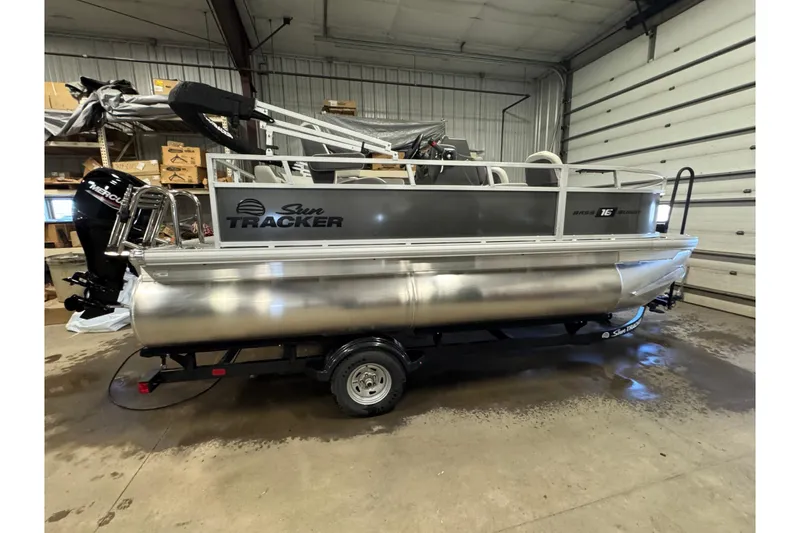 The Image of 2026 Sun Tracker Bass Buggy 16 XL Select pontoon boat in a garage setting. - 0