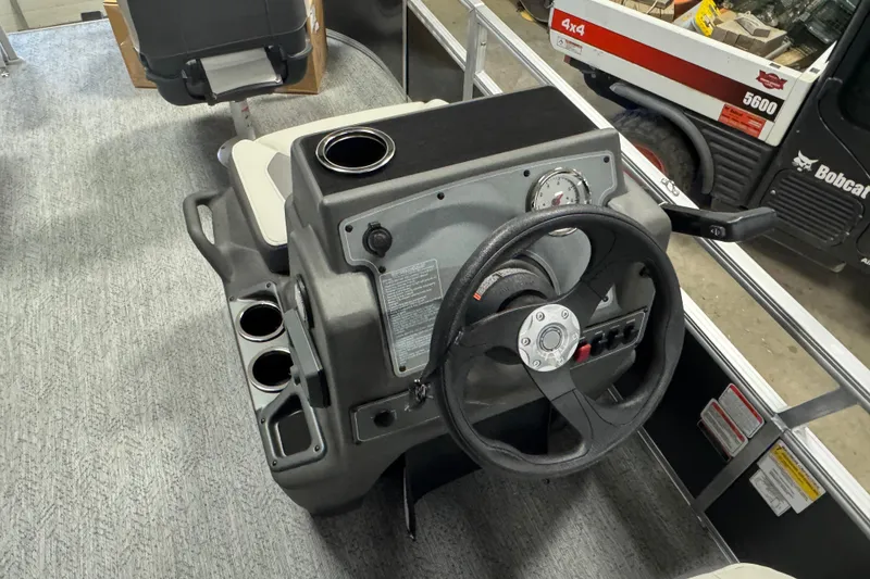 Slide: The Image of 2026 Sun Tracker Bass Buggy 16 XL Select steering console with cup holders and controls. - 10