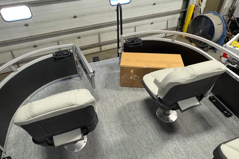 Slide: The Image of 2026 Sun Tracker Bass Buggy 16 XL Select interior with seating and cardboard box. - 16
