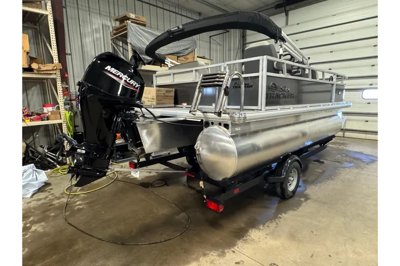 Slide: The Image of 2026 Sun Tracker Bass Buggy 16 XL Select pontoon boat in a garage setting. - 3