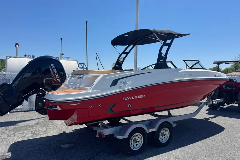 Slide: The Image of 2024 Bayliner VR6 Bowrider OB in red, on trailer, with Mercury outboard motor. - 1