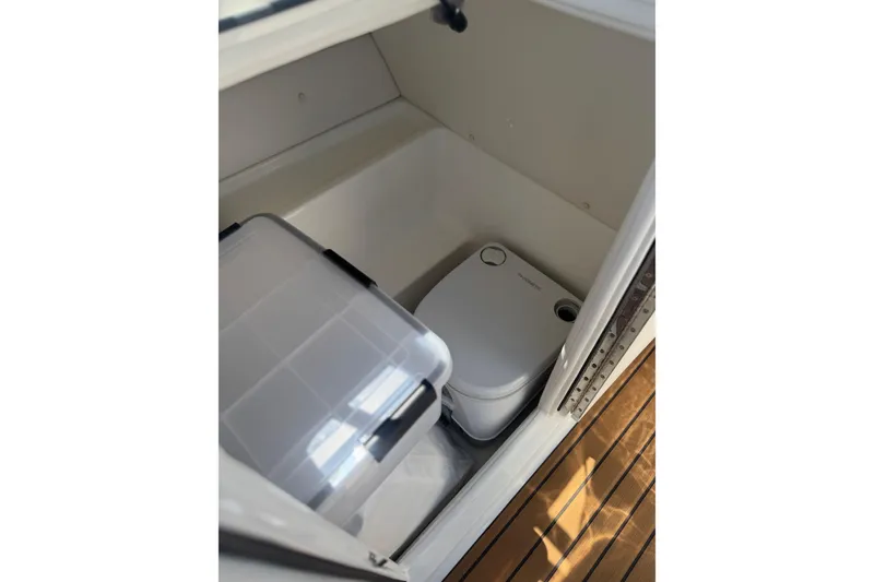 Slide: The Image of 2024 Bayliner VR6 Bowrider OB interior storage with portable toilet and container. - 13
