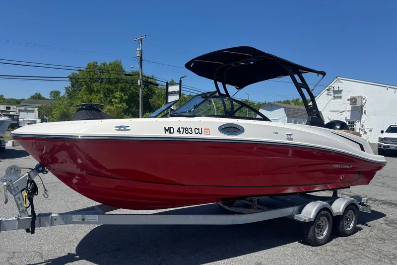 Slide: The Image of 2024 Bayliner VR6 Bowrider OB in red on a trailer, parked outdoors. - 3