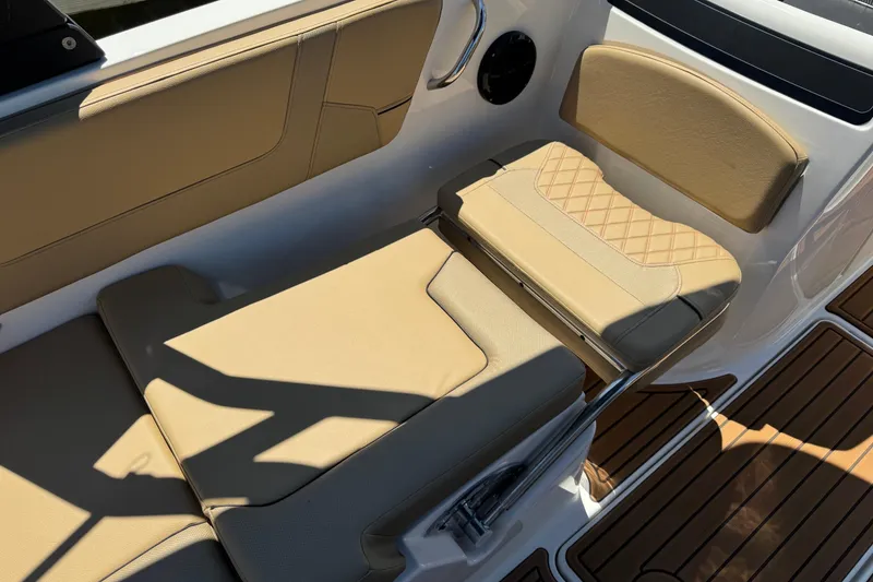 Slide: The Image of 2024 Bayliner VR6 Bowrider OB interior with tan seating and wood-style flooring. - 4