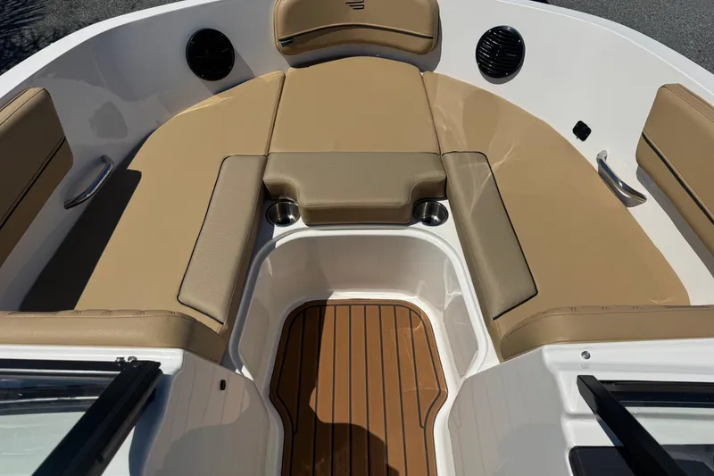 Slide: The Image of 2024 Bayliner VR6 Bowrider OB interior with tan seating and wood-style flooring. - 8