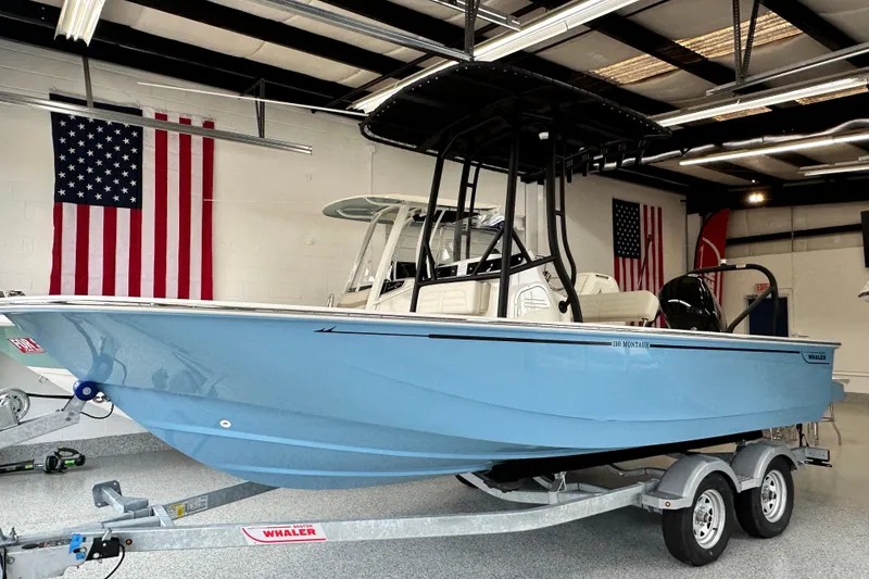The Image of 2026 Boston Whaler 190 Montauk boat in showroom, featuring sleek design and American flags. - 17