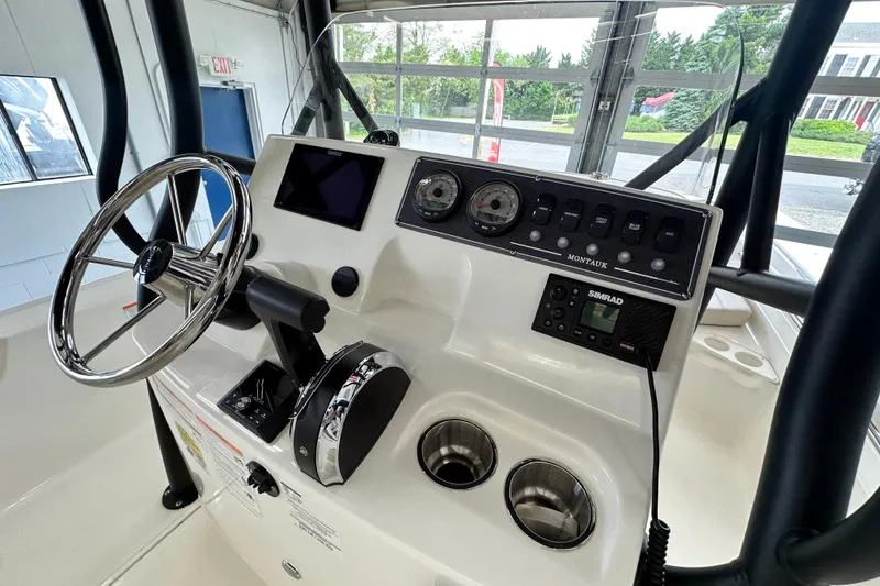 Slide: The Image of 2026 Boston Whaler 190 Montauk boat dashboard with steering wheel and control panel. - 23