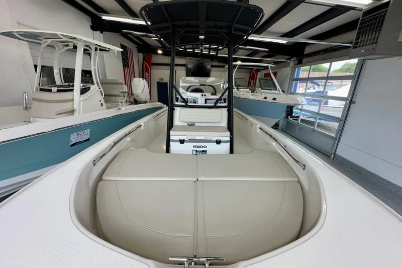 Slide: The Image of 2026 Boston Whaler 190 Montauk boat interior in showroom, featuring seating and storage. - 25