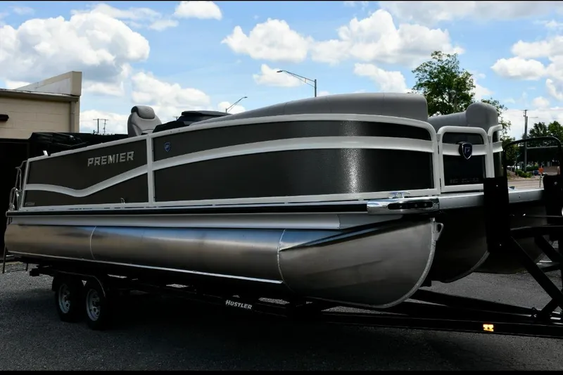 The Image of 2024 Premier 250 RL PTX pontoon boat on trailer under a cloudy sky. - 1