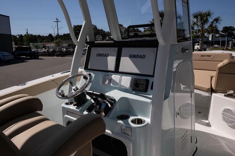 Slide: The Image of 2026 Sea Pro 265FLX Sandbar boat interior with dual Simrad displays and beige seating. - 10