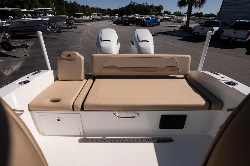 Slide: The Image of 2026 Sea Pro 265FLX Sandbar boat with beige seating and dual engines in a marina. - 13