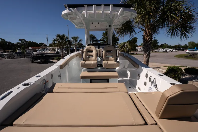Slide: The Image of 2026 Sea Pro 265FLX Sandbar boat with beige seating, parked near palm trees. - 15