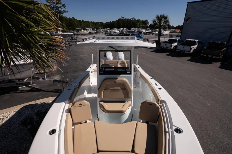 Slide: The Image of 2026 Sea Pro 265FLX Sandbar boat with beige seating, parked in a marina. - 19