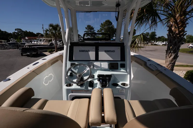 Slide: The Image of 2026 Sea Pro 265FLX Sandbar boat cockpit with dual Simrad displays and beige seating. - 8