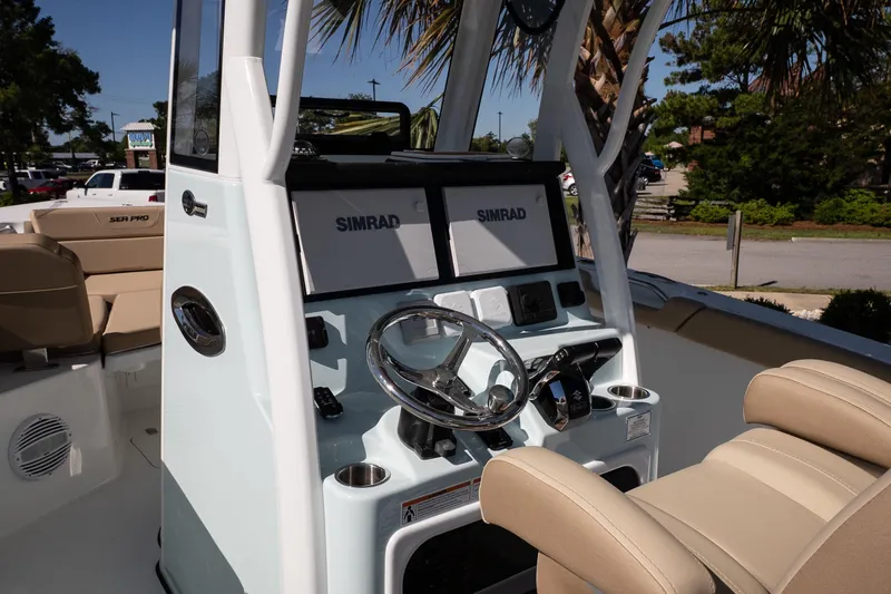 Slide: The Image of 2026 Sea Pro 265FLX Sandbar boat dashboard with Simrad navigation system and beige seating. - 9